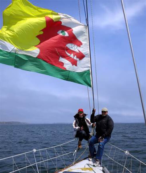 Hoisting CHARIAD battle flag while sailing past Beverly Yacht Club