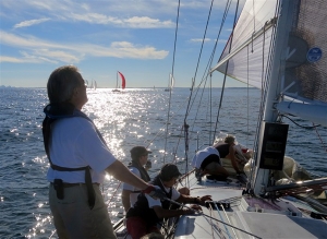 CHARIAD crew and foredeck, sailboat with red spinnaker in distance